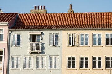 Green and yellow historic terraced houses in Nyhavn in the center of Copenhagen in Denmark