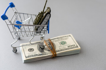 toy tank on the background of dollar bills