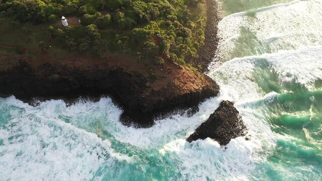 Aerial looking down and across the ocean rushing through the rocks Giant's causeway at sunset.
