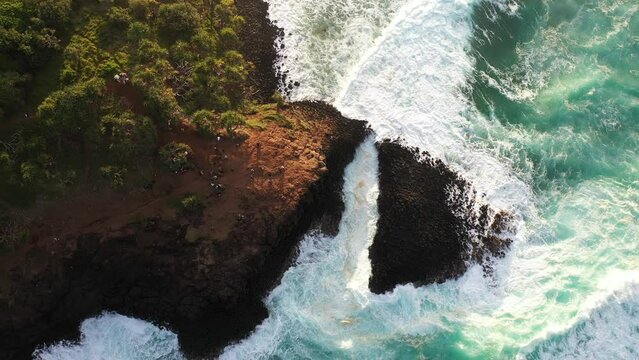 Aerial over Fingal Head and the ocean rushing through Giant's causeway.