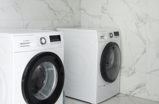 Kyiv, Ukraine - April 14, 2022: Bosch washing and drying machine with settings on digital display and modern control panel.  Laundry at home and daily housework routine concept.