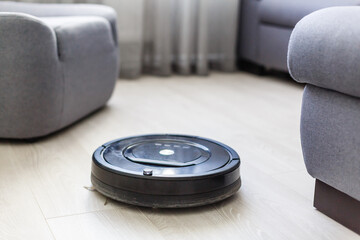 Obraz premium Robot vacuum cleaner, robot vacuum cleaner wipes floors, power button is on and ready to work