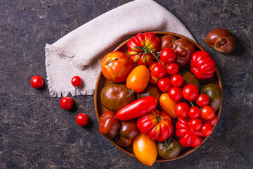 The harvest of assorted tomatoes. Colorful organic tomatoes on a large dish. Tomatoes different varieties. Top view
