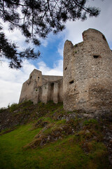 Low angle view of the circular tower of a castle in ruins. Architectural parts of a castle in ruins, the fortified circular tower and the walls.