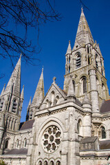 Fototapeta premium The spires of the Anglican Cathedral of St. Fin Barre in the Irish city of Cork. A Christian church in the Neo-Gothic style. Cloudless sky over the church. Christian religious architecture.