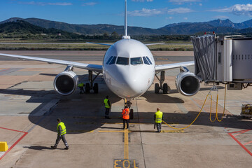 Plane in boarding position on the tarmac while waiting at the airport, hustle and bustle of the airport staff before takeoff