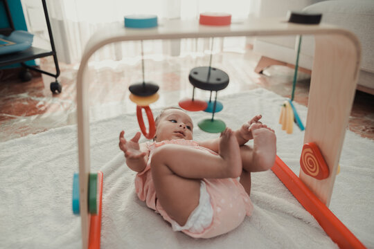 Newborn baby playing on an activity mat at home