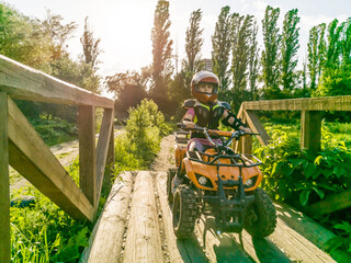 A child rides a quad bike through the mud. ATV rider rides