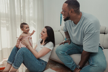 Multicultural family playing with a newborn at home
