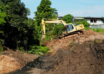 excavator on a construction site. excavator in the ground. Excavators are digging clogged canals to drain water ahead of the rainy season.