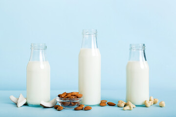 Set or collection of various vegan milk almond, coconut, cashew, on table background. Vegan plant based milk and ingredients, top view