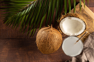 Fototapeta na wymiar Glass with fresh coconut water and coconuts on the table.