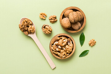 Walnut kernel halves, in a wooden bowl. Close-up, from above on colored background. Healthy eating Walnut concept. Super foods with copy space