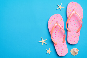Flat lay composition with flip flops and seashell on colored background. Space for text top view