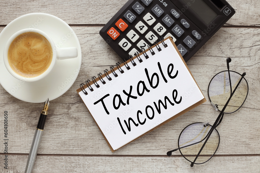Poster taxable income top view of notepad with text and calculator. cup of coffee on the work table