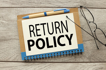 RETURN POLICY text on a page on a notepad on a desktop