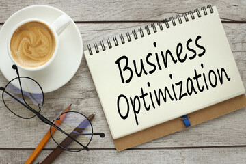 business optimization concept. On a wooden background, a notepad with text with a cup of coffee and glasses