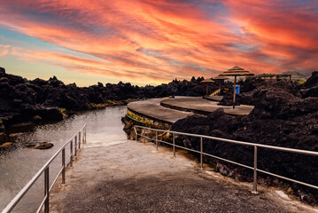 Natural pools at Biscoitos during a dramatic sunset in the coast of Terceira Island, Azores, Portugal