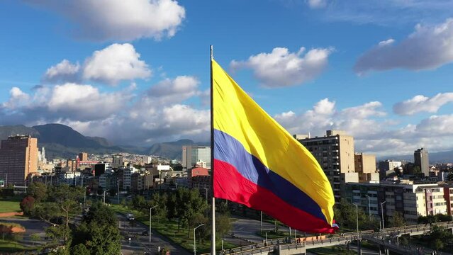 View from a drone of the Colombian flag on a flagpole moved by the wind and the city of Bogot&aacute; in the background. Cundinamarca. Colombia. May 2023.