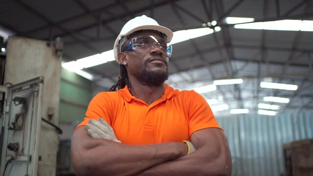 Happy cheerful African ethnicity senior engineer making an arms crossed, senior factory technician smiling portrait.