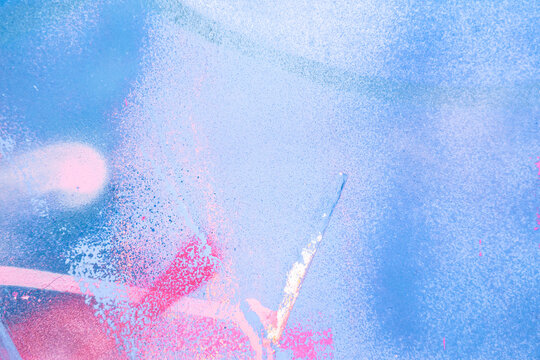 Messy paint strokes and smudges on an old painted wall. Purple, blue, pink, magenta, white drips, flows, streaks of paint and paint sprays