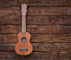 ukulele guitar isolated on wooden background. Space for text. Music background