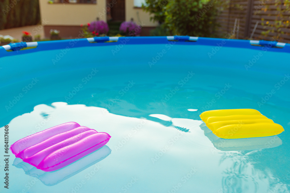 Wall mural Two inflatable pillows lie on the surface of the water in the pool