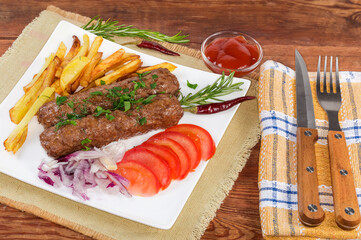 Lula kebab with French fries on dish on rustic table