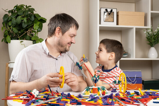 Dad and son build figures from the constructor. Spending time together, the role of the father in the child's life