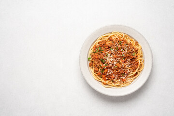 Spaghetti bolognese pasta in ceramic plate on light gray background. Italian traditional cuisine