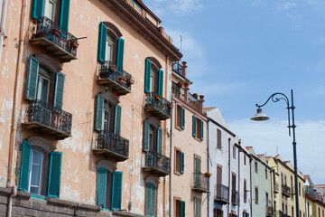 Fototapeta na wymiar Shabby facades of different pastel colours on the street of Bosa, Sardinia, Italy