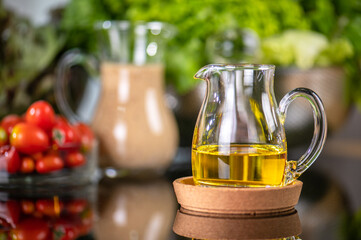 homemade sauces of salad dressings and olive oil in small glass jug including Japanese sesame seed. Glass jug of Japanese sesame seed salad dressings and olive oil.