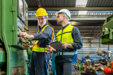 Two professional engineer worker technician assistant in helmet inspection check old machine construction factory with colleague manager. check old machinery production construction operating