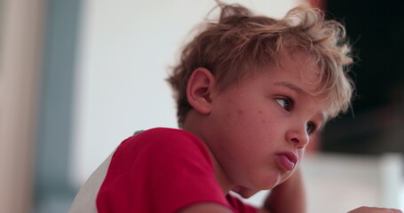Contemplative toddler kid face thinking. Bored child boy lost in thought