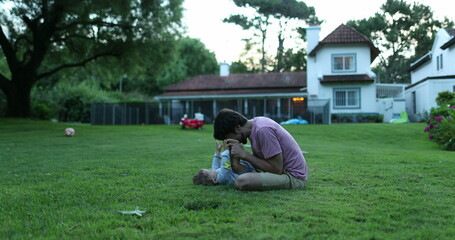 Fototapeta premium Father bonding with baby infant son in outdoor home garden