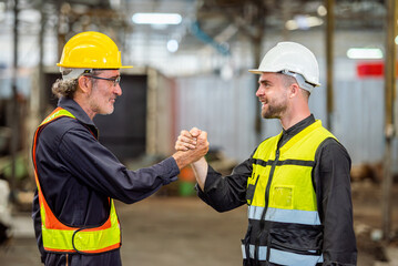 Fototapeta na wymiar greeting by handshake touch fist and elbow of two engineer supervisor partnership in old factory. foreman greeting friend for good friendship colleague laborer in teamwork factory.