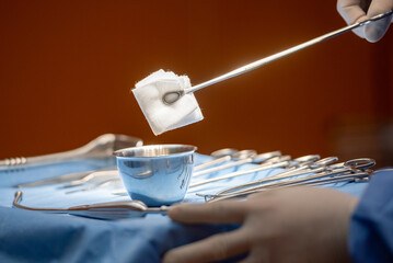 Hand of surgery doctor in Operating Room hold operating plier forceps tweezer pinch gauze and Dip...