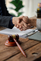 Fototapeta na wymiar Lawyers shake hands with clients who come to testify in the case of embezzlement from business partners who jointly invest in the business. The concept of hiring a lawyer for legal proceedings.