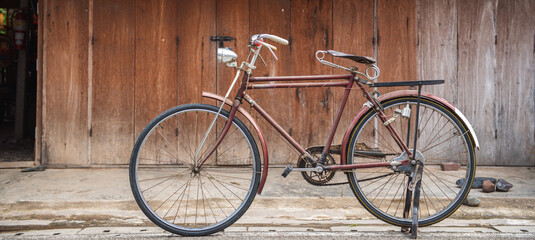 Banner panorama size of Vintage bicycle on old rustic dirty wall house, many stain on wood wall....