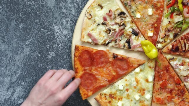 The perfect balance of sauce, cheese, and different toppings on pizza on a circular tray is a feast for the senses, as seen by the person enjoying a slice with just one hand