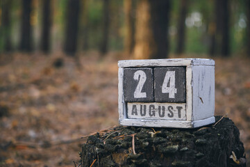 August 24 summer month, wooden calendar with date and month in forest.Waffle day.
