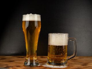 A glass of cold beer on a dark background. Glass of beer close-up.