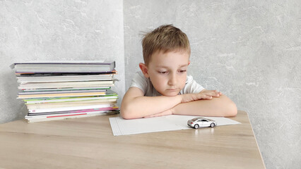 Tired boy with ADHD is bored in class, distracted, does not want to do homework. Therapy for ADHD children.  Attention deficit and hyperactivity in children, neuropsycho