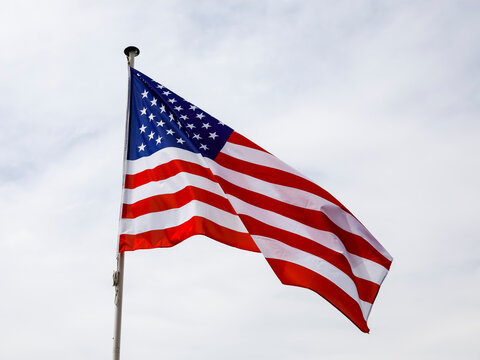 Flag of the United States against cloudy sky