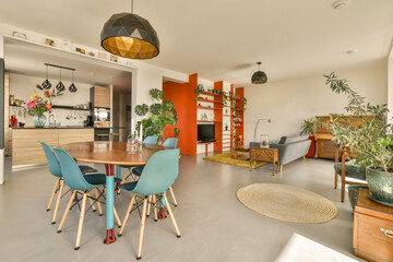 a living room and dining area in an apartment with plants on the table, chairs and televisions...