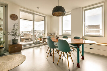 a dining table and chairs in a room with large windows that look out onto the cityscaped view