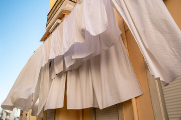 White linen drying on a rope in the sun, clotheslines in an old town in Lisbon, Portugal