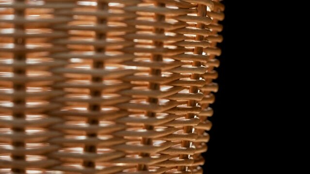 Fragment of a basket made of willow twigs or garden furniture. On black background