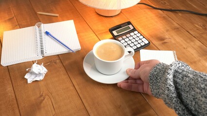A man serves coffee on a wooden table.
