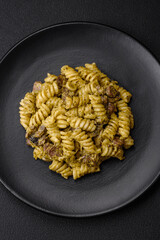 Delicious fusilli pasta with green pesto sauce, with salt and spices